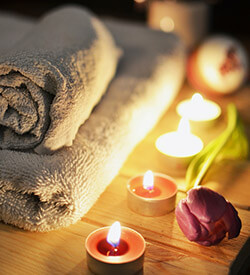 Rolled towel, tea candles, and a red tulip